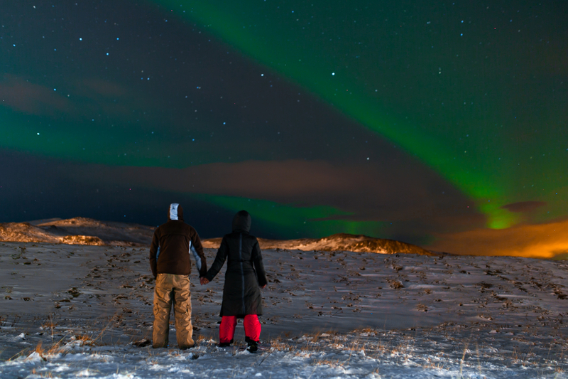 couple-on-a-babymoon-during-winter-in-iceland-in-the-dark-night-looking-at-the-aruora-above