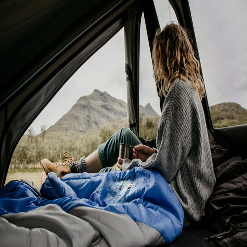 ženska pije kavo v šotoru na strehi