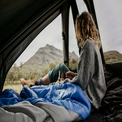 Eine Frau trinkt Kaffee beim Camping in Askja