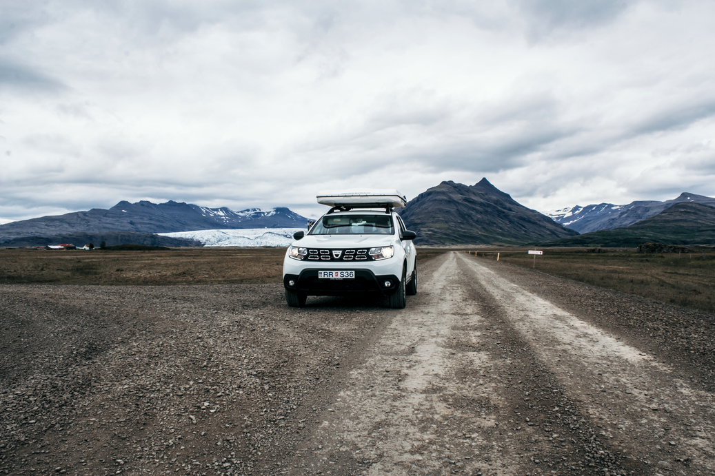 Roof top tent Dacia Duster surrounded by mountains in Iceland