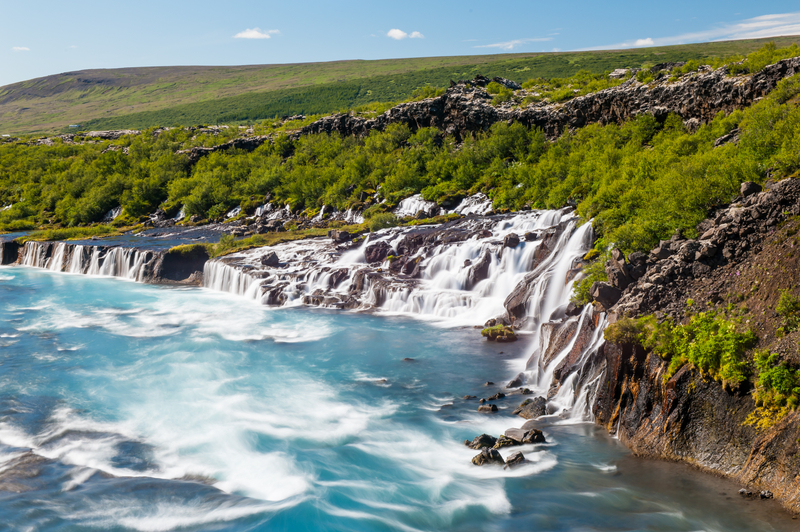Hraunfossar-waterfall-in-iceland-water-flowing-from-underneath-the-lava-fields-and-trees