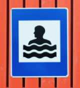 swimming-pool-sign-in-Iceland-blue-frame-with-black-figure-in-water-on-a-white-background