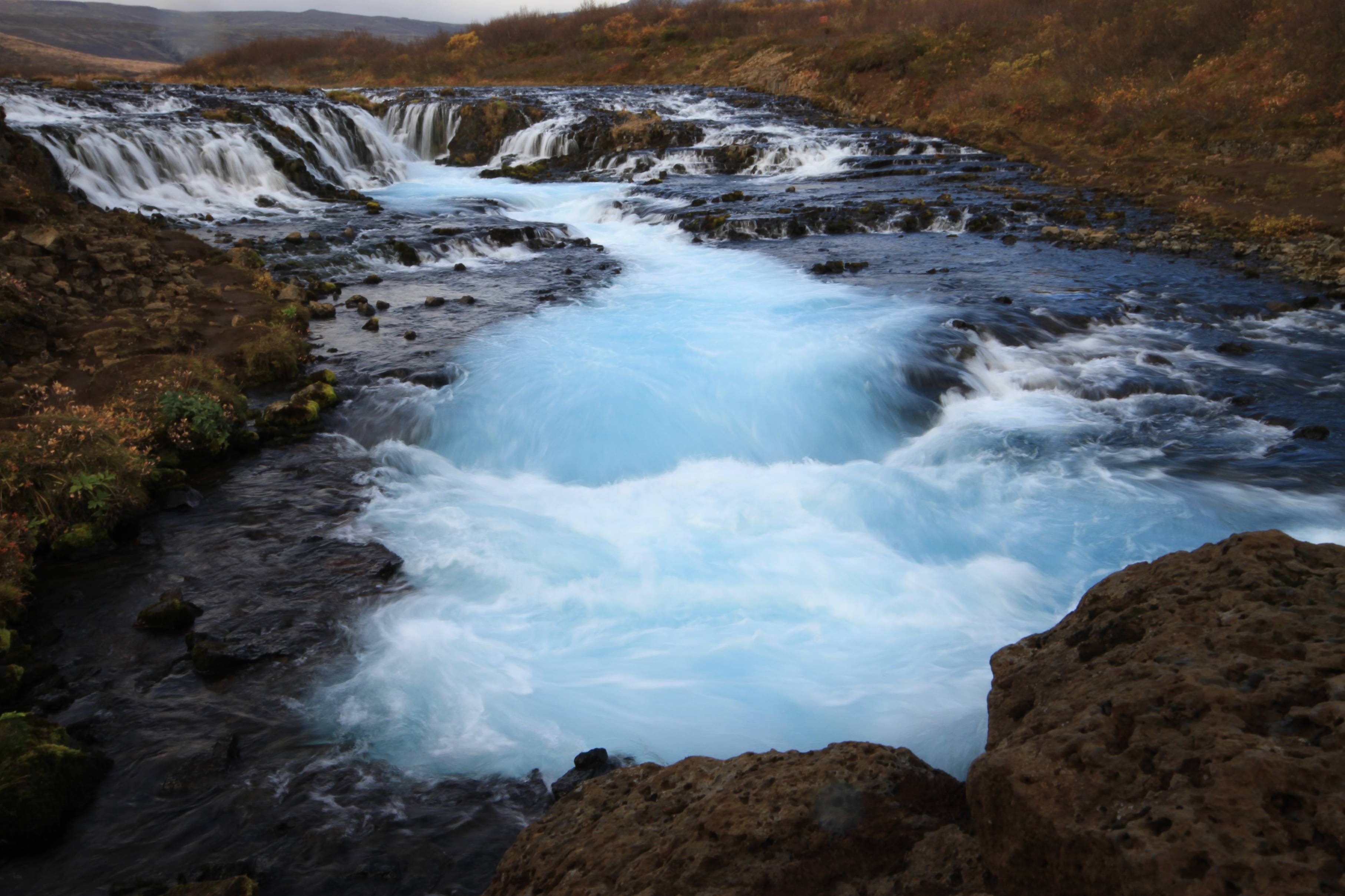 Bruarfoss-waterfall-in-iceland-bright-blue-glacier-water-running-down-from-lava-field-on-a-fall-day